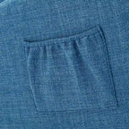 Mecedora tapizada azul 27 con patas de madera y práctico bolsillo lateral